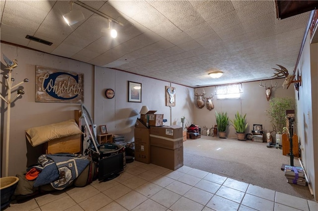 interior space with light tile patterned floors, visible vents, and light carpet