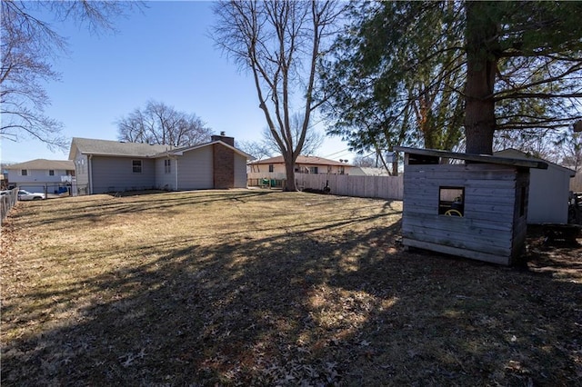 view of yard with an outdoor structure, fence, and a shed