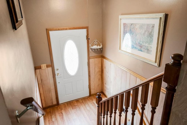 foyer entrance featuring plenty of natural light, wainscoting, stairs, and wood finished floors