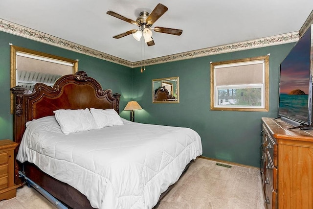 bedroom with baseboards, a ceiling fan, and light carpet
