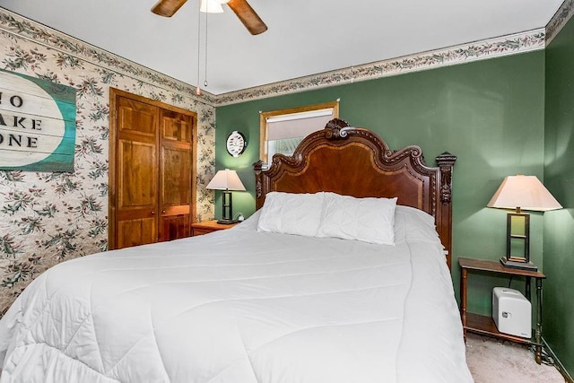 carpeted bedroom featuring wallpapered walls and ceiling fan
