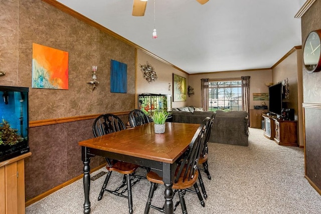 dining room featuring light carpet, crown molding, and ceiling fan