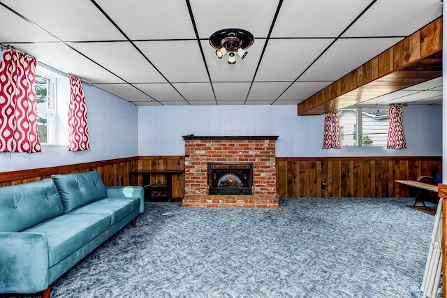 living area with a paneled ceiling, wooden walls, a wainscoted wall, and carpet floors