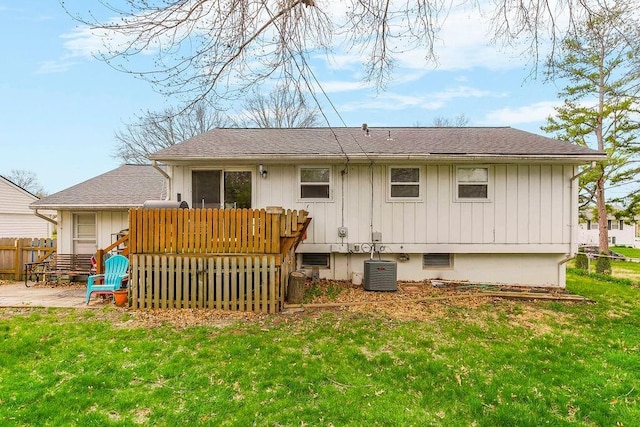 rear view of house featuring central air condition unit, a lawn, a deck, fence, and a shingled roof