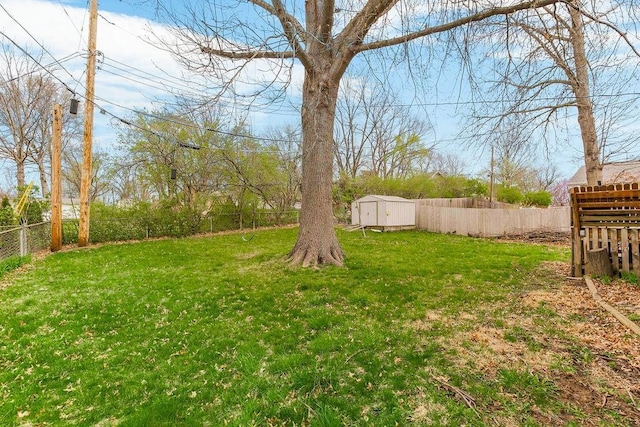 view of yard with an outdoor structure, a storage shed, and a fenced backyard