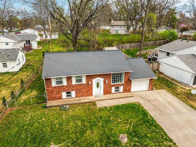 view of front of house with a front yard, brick siding, fence private yard, and driveway