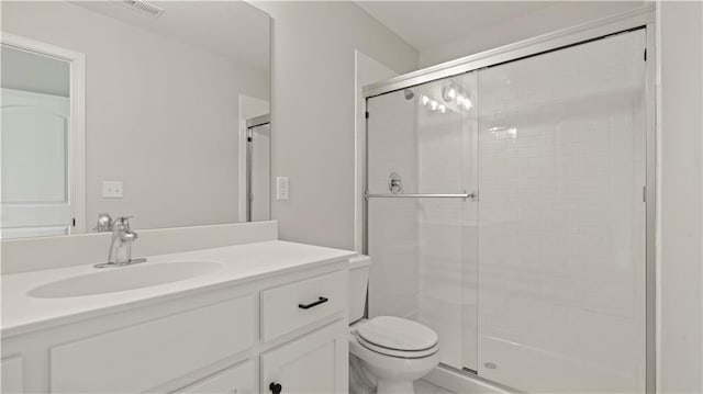 bathroom with toilet, a stall shower, visible vents, and vanity