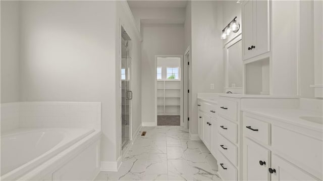 bathroom with marble finish floor, a shower stall, vanity, baseboards, and a bath