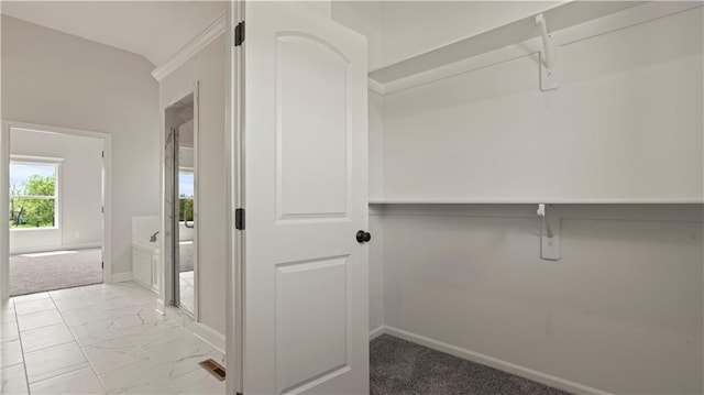 spacious closet featuring light carpet and marble finish floor