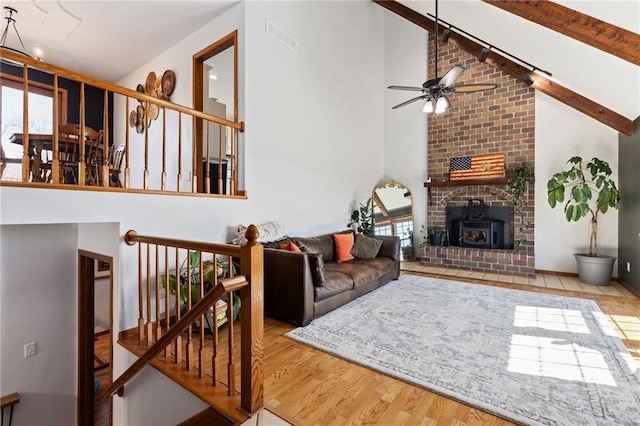 living room featuring a healthy amount of sunlight, wood finished floors, visible vents, and ceiling fan