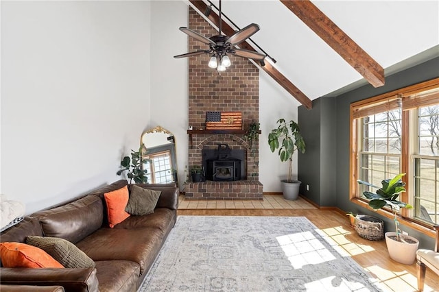 living room featuring beam ceiling, a healthy amount of sunlight, wood finished floors, and a ceiling fan