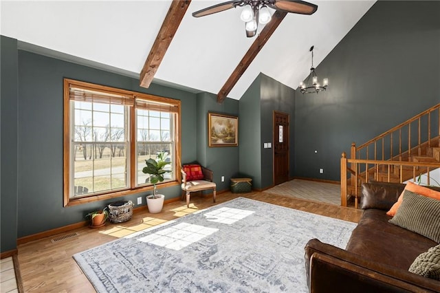 living area with stairway, wood finished floors, visible vents, beam ceiling, and ceiling fan with notable chandelier