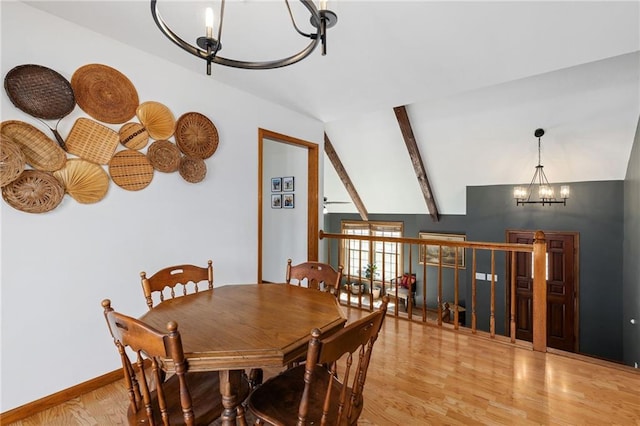 dining area featuring baseboards, a notable chandelier, vaulted ceiling with beams, and light wood-style floors