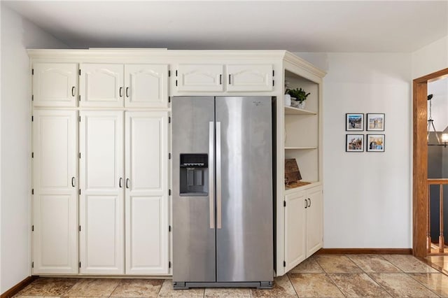 kitchen featuring white cabinetry, stainless steel fridge with ice dispenser, and baseboards