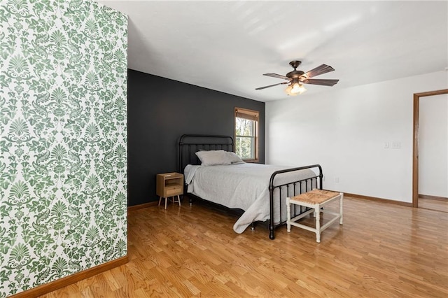 bedroom featuring light wood-style floors, baseboards, and ceiling fan