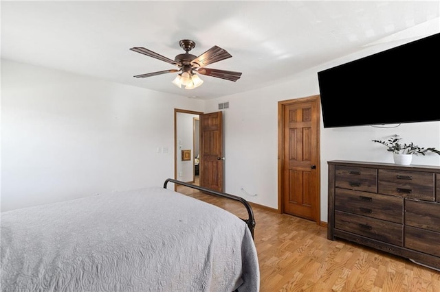 bedroom with ceiling fan, visible vents, baseboards, and light wood-style flooring