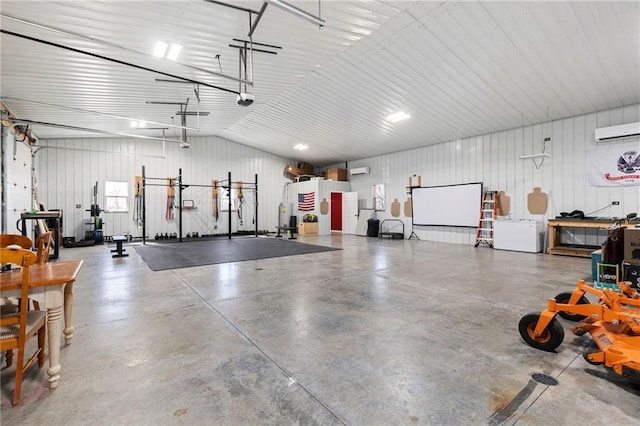 garage featuring a wall unit AC, a garage door opener, and metal wall