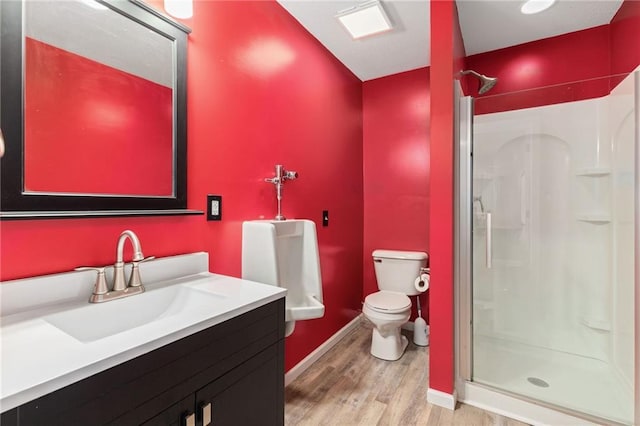 full bathroom featuring wood finished floors, toilet, a stall shower, and vanity