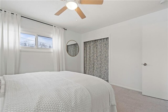 carpeted bedroom with baseboards, a ceiling fan, and a closet