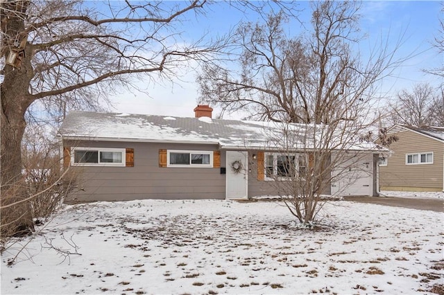 ranch-style home with a garage and a chimney