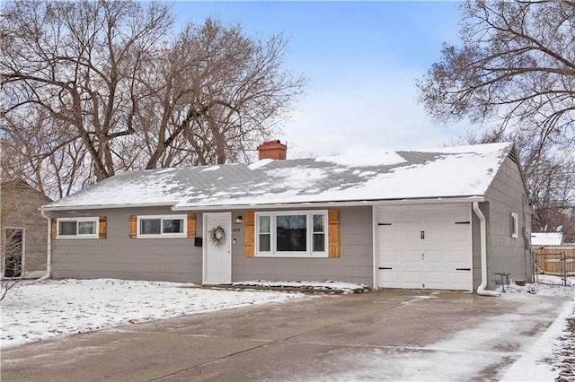 ranch-style house featuring a garage, driveway, fence, and a chimney