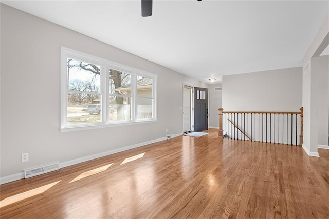 spare room featuring visible vents, baseboards, and wood finished floors