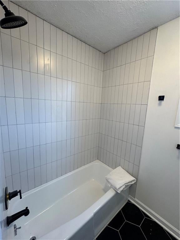 bathroom with tile patterned flooring, a textured ceiling, and baseboards