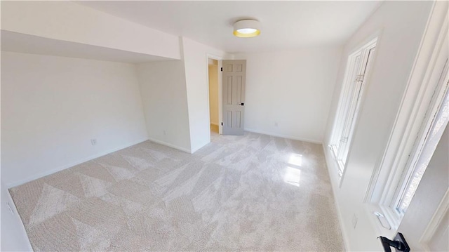 unfurnished bedroom featuring baseboards and light colored carpet