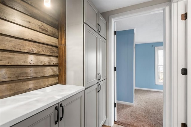 interior space with baseboards and light colored carpet