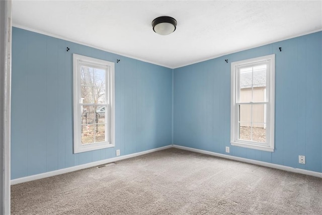 unfurnished room featuring carpet, visible vents, and baseboards