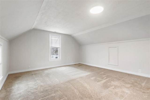 additional living space featuring carpet flooring, vaulted ceiling, and baseboards