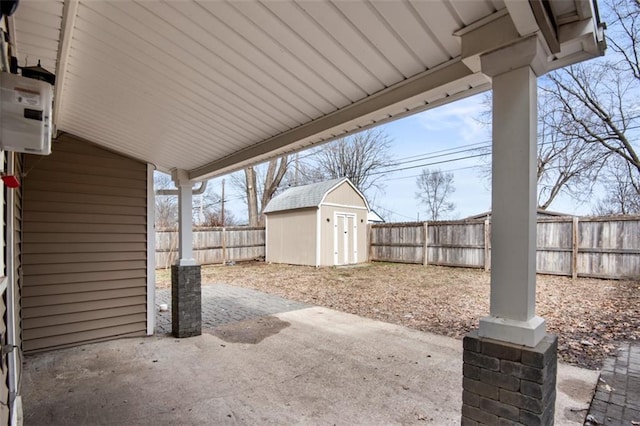 view of patio / terrace with an outbuilding, a fenced backyard, and a storage shed