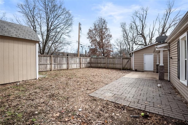 view of yard featuring an outbuilding, a patio, and a fenced backyard