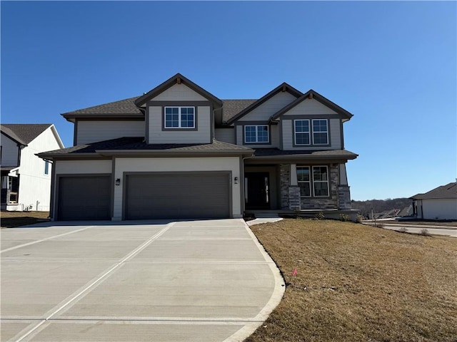 craftsman house with a garage, stone siding, and driveway