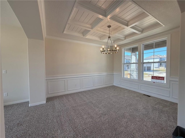 carpeted empty room featuring a notable chandelier, coffered ceiling, visible vents, beamed ceiling, and crown molding