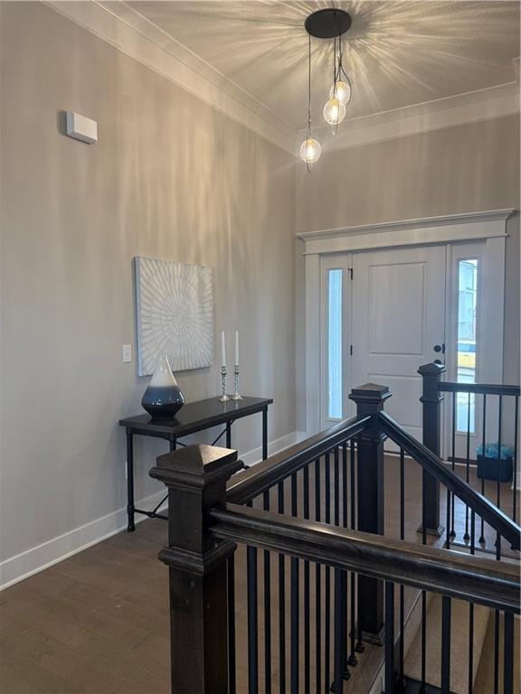 entrance foyer with dark wood finished floors, crown molding, and baseboards