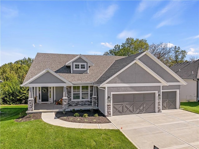 craftsman house with a garage, stone siding, a front lawn, and stucco siding