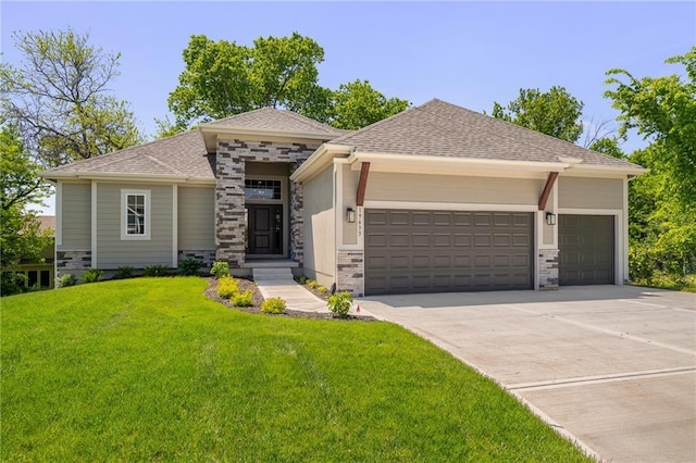 prairie-style house featuring an attached garage, a shingled roof, concrete driveway, stone siding, and a front lawn