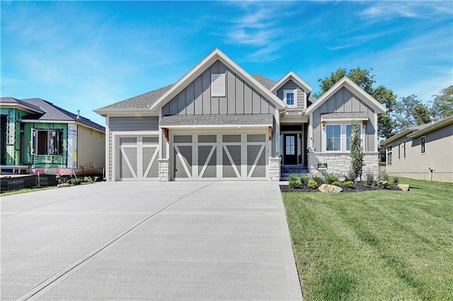 view of front facade featuring board and batten siding, a garage, stone siding, driveway, and a front lawn