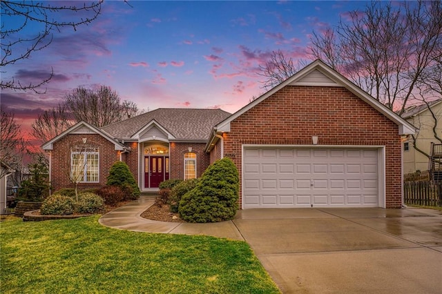 ranch-style house featuring driveway, brick siding, a shingled roof, an attached garage, and a front yard