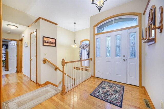 entrance foyer with wood finished floors, visible vents, and baseboards