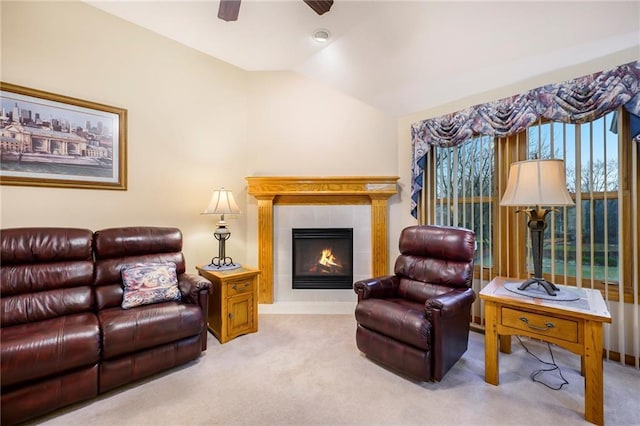 carpeted living area featuring ceiling fan, vaulted ceiling, and a tiled fireplace