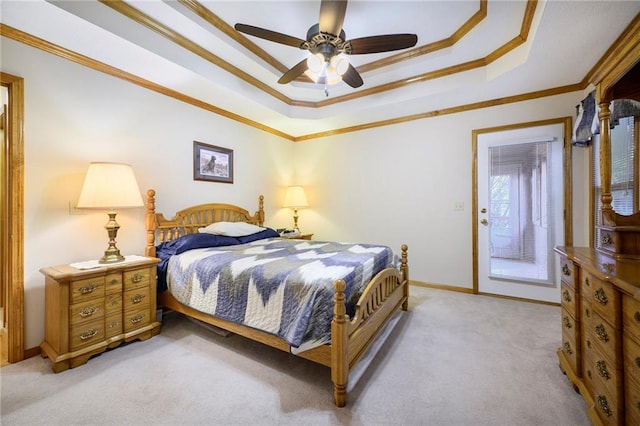 bedroom with a tray ceiling, light colored carpet, ornamental molding, ceiling fan, and baseboards