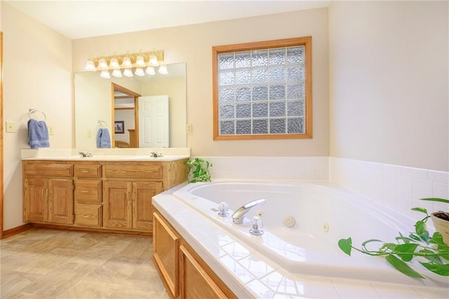 bathroom featuring a jetted tub, double vanity, and a sink