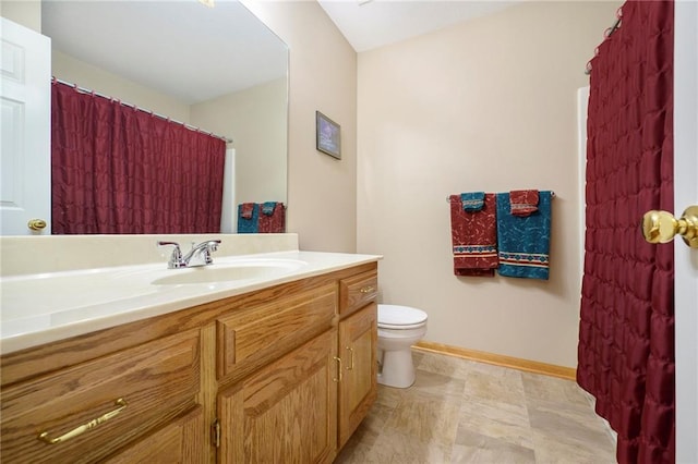 bathroom with vanity, toilet, and baseboards