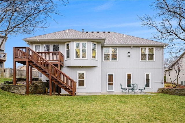 rear view of house with a yard, a wooden deck, stairs, and a patio