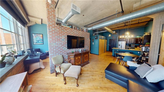 living area with light wood-type flooring and a towering ceiling