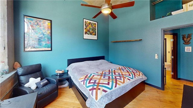 bedroom featuring ceiling fan, light wood-style flooring, and baseboards