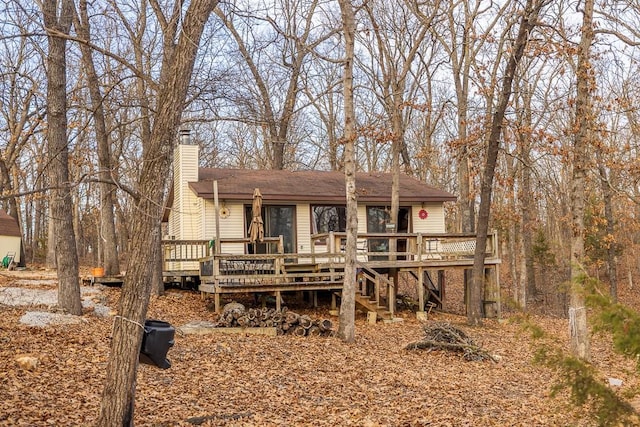 view of front of property with a chimney, a deck, and stairs