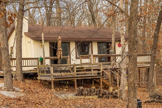 back of property with a chimney, stairway, and a deck